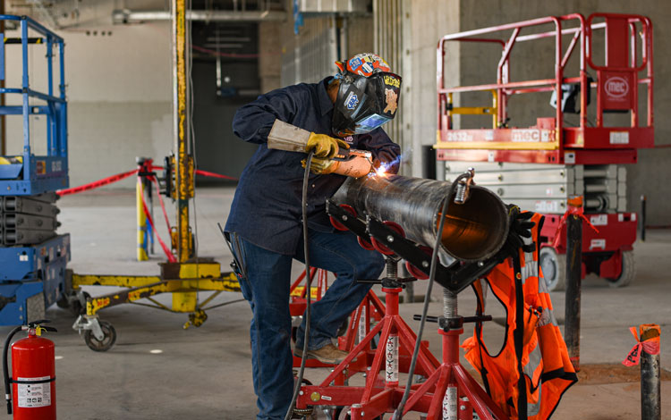 Kaylin Leas Welding a pipe.